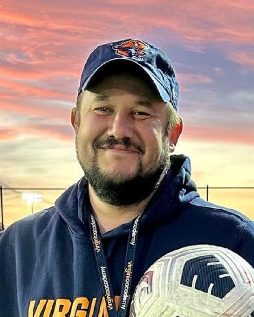 Image of Athletic Coordinator Adam Staats wearing a Virginia Academy hat and holding a soccer ball.